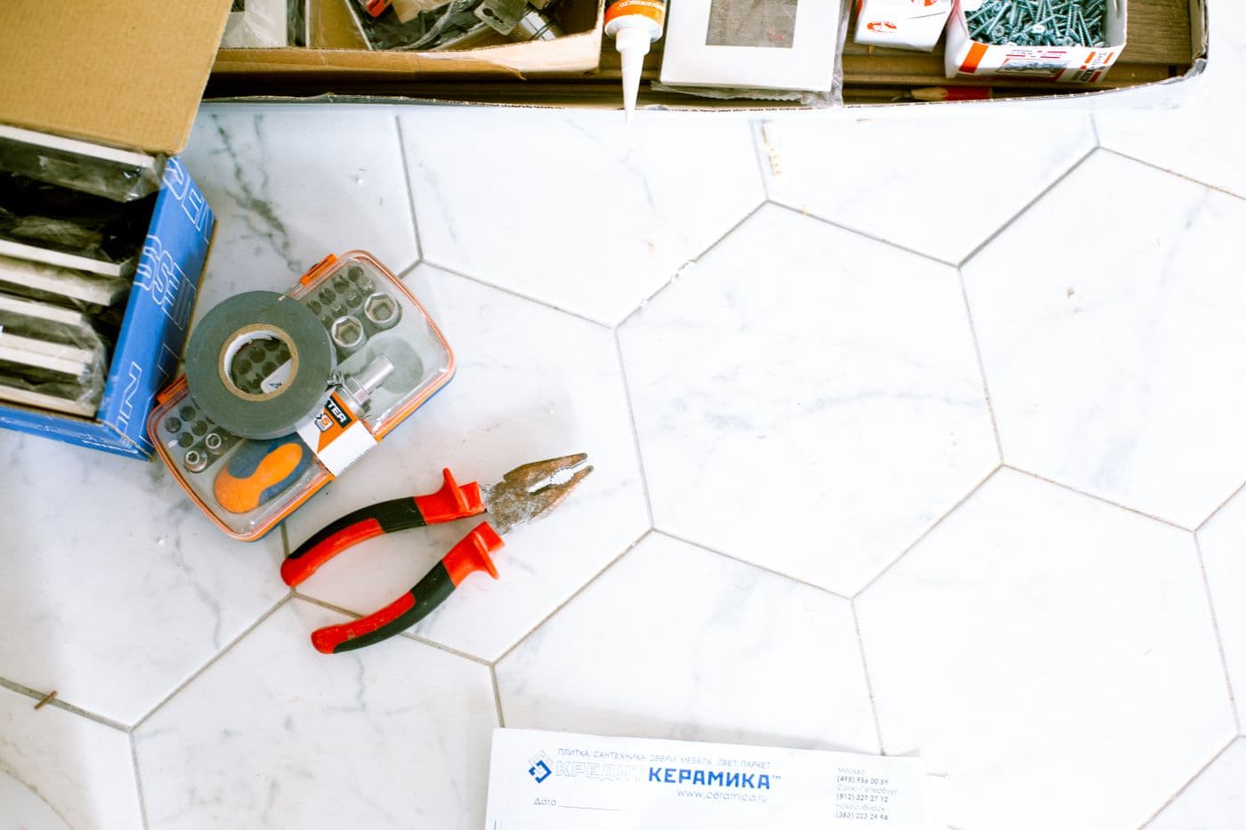 Home repair tools organized on a tiled work surface